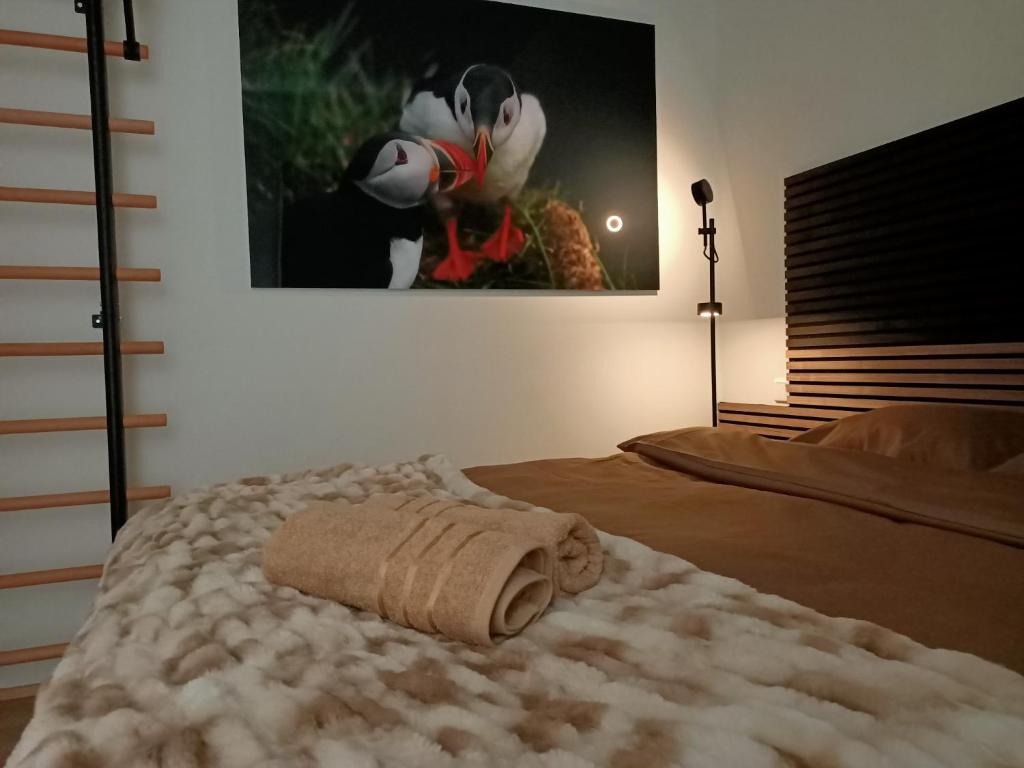 a bedroom with a bed with a towel on it at Puffin Nest, Superior Apartment in Reykjavík