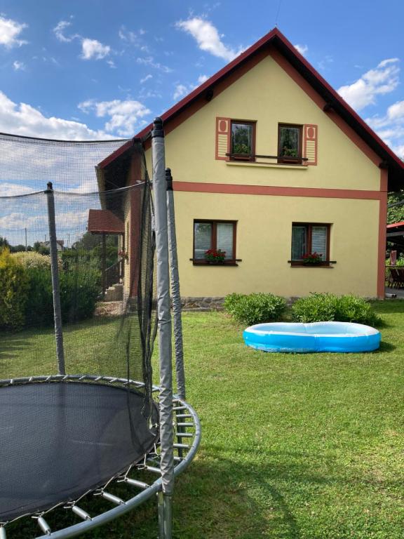 a house with a trampoline in the yard at Apartmány Lucie in Karlovice