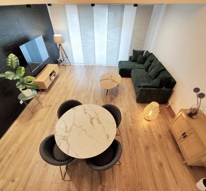 a living room with a table and chairs and a couch at Superbe Cosy Duplex Appartement T3 Charpenne Tête D'or avec parking privé gratuit in Villeurbanne