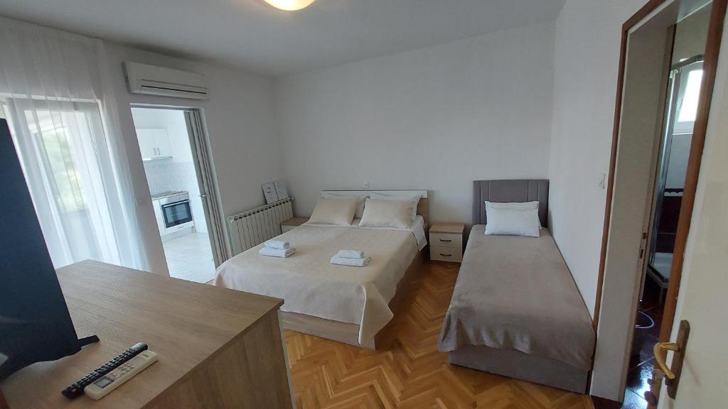 a bedroom with two beds and a large mirror at Karmen in Kampor