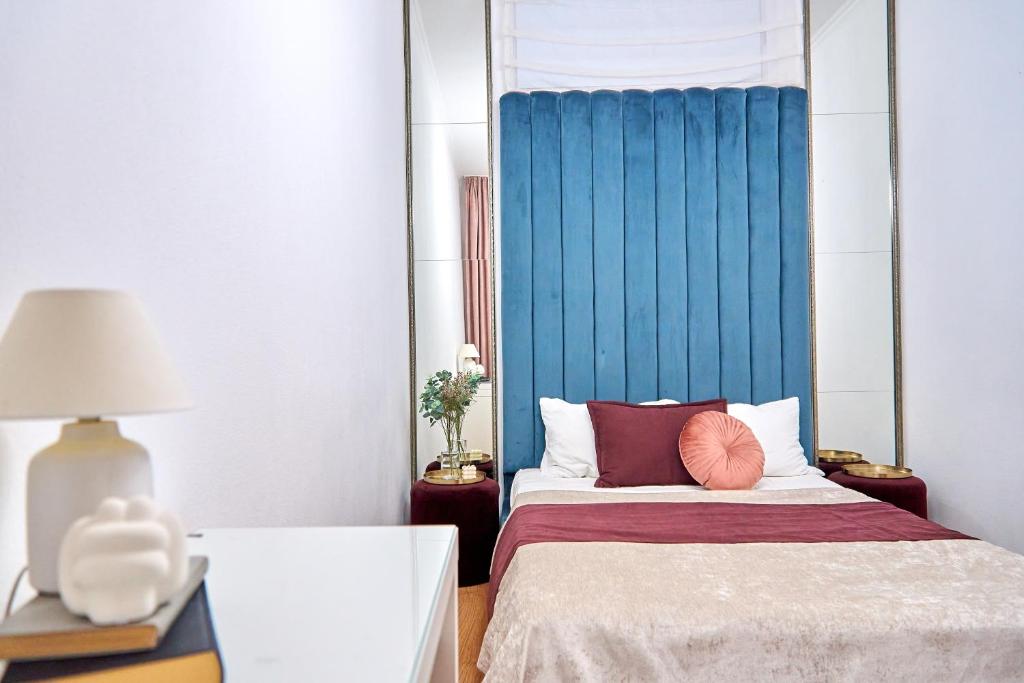 een slaapkamer met een bed met een blauw hoofdeinde bij Стильні Апартаменти на Ратушній площі in Mukacheve