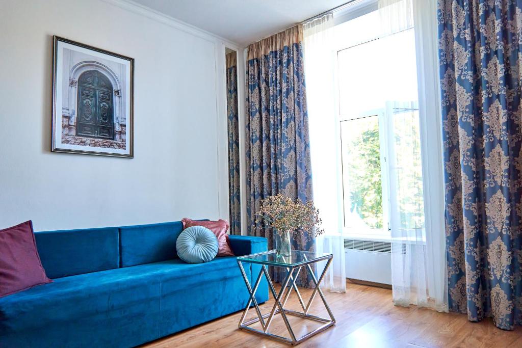 a blue couch in a living room with a window at Стильні Апартаменти на Ратушній площі in Mukacheve