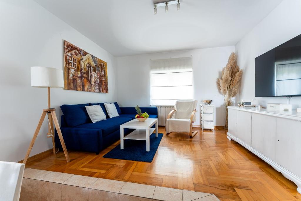 Apartment Borik في بييلوفار: غرفة معيشة مع أريكة زرقاء وطاولة