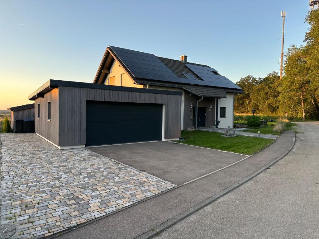 a house with a garage and a driveway at Haus am Wald in Schrozberg