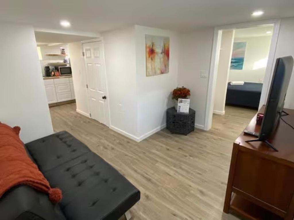 uma sala de estar com um sofá e uma televisão de ecrã plano em Private Bedroom Studio Downtown em Stamford