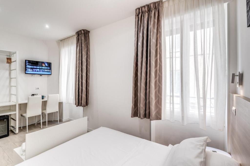 Hotel A Touch of Rome Guesthouse, a white bedroom with a bed and a window at A Touch of Rome Guesthouse in Rome