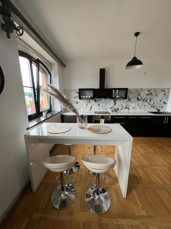 a kitchen with a white table and two stools at Apartamenty Dekora in Żary