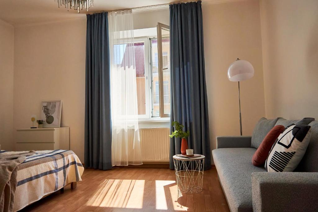 a living room with a blue couch and a window at Wonderful Panoramic View Apartment in Mukacheve