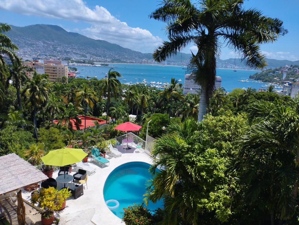 vista su un resort con piscina e palme di Casa Breizh ad Acapulco