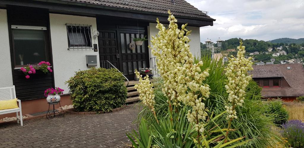 a garden with yellow flowers in front of a house at Ferienwohnung Wahlich in Idar-Oberstein