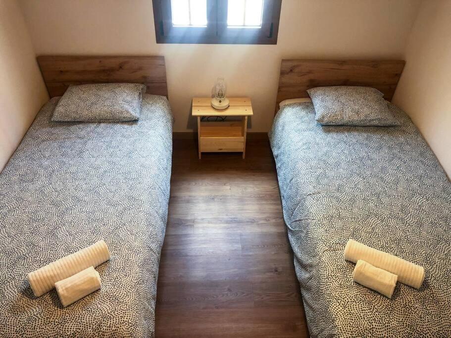 two beds in a room with a desk and a bed sidx sidx sidx at Casa da Praça in Freixo de Numão