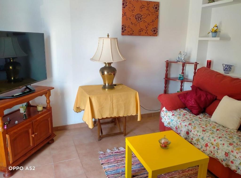 una sala de estar con sofá y una lámpara en una mesa. en Sea Breeze House, en Almuñécar