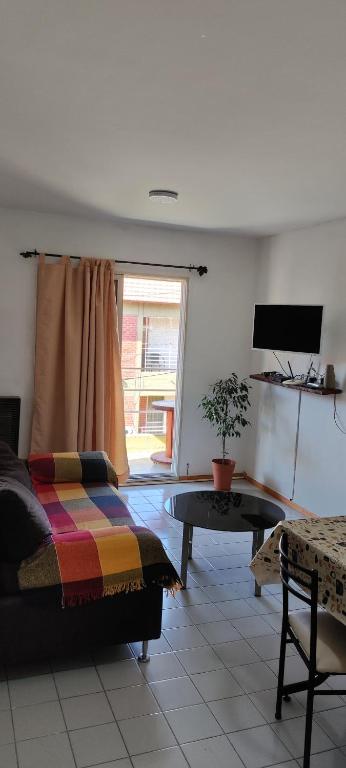 una sala de estar con una cama y una mesa en Dpto Bon Lee, en Puerto Madryn