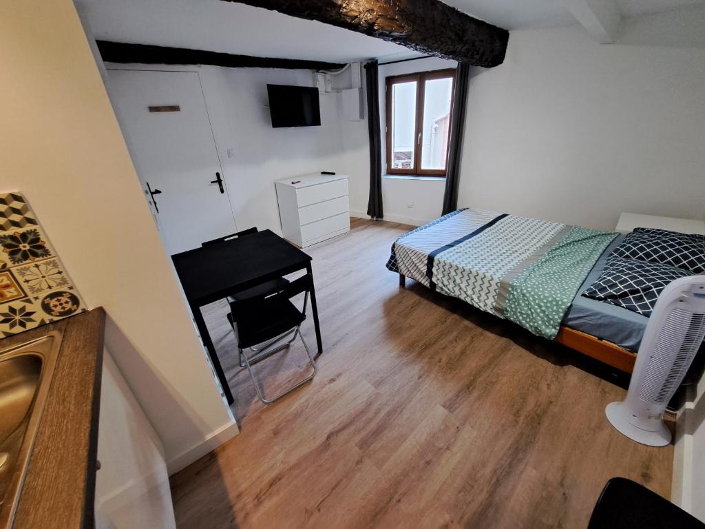 a bedroom with a bed and a desk in a room at BudgetBnb Studio centre ancien in Hyères