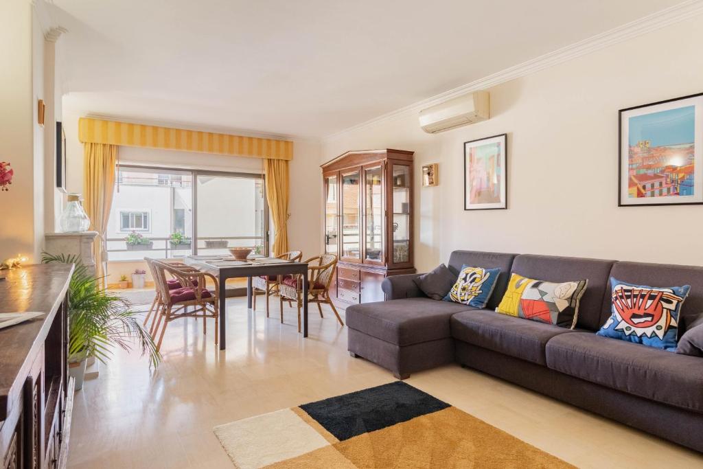 a living room with a couch and a table at Central Cascais Apartment with private parking in Cascais