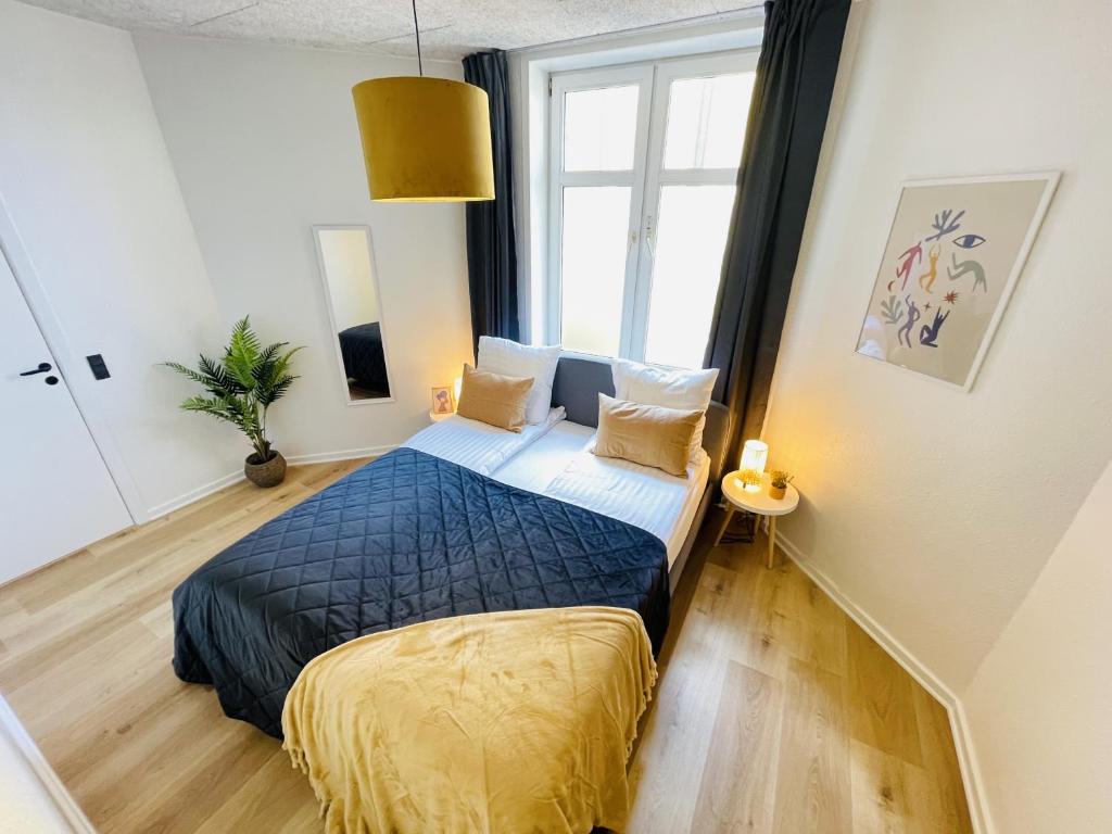 a bedroom with a bed and a large window at aday - Frederikshavn apartment on the Pedestrian street in Frederikshavn
