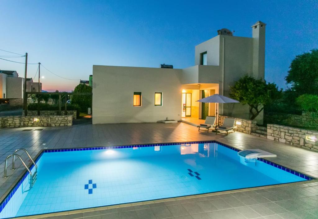 a swimming pool in front of a house at Villa Athina in Asprouliánoi