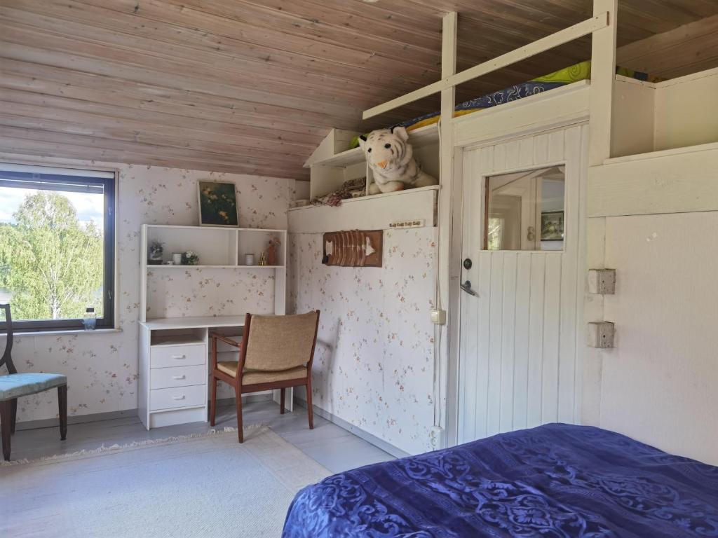 a bedroom with a bed and a desk and a chair at Embracing nature's Swedish house in Ludvika