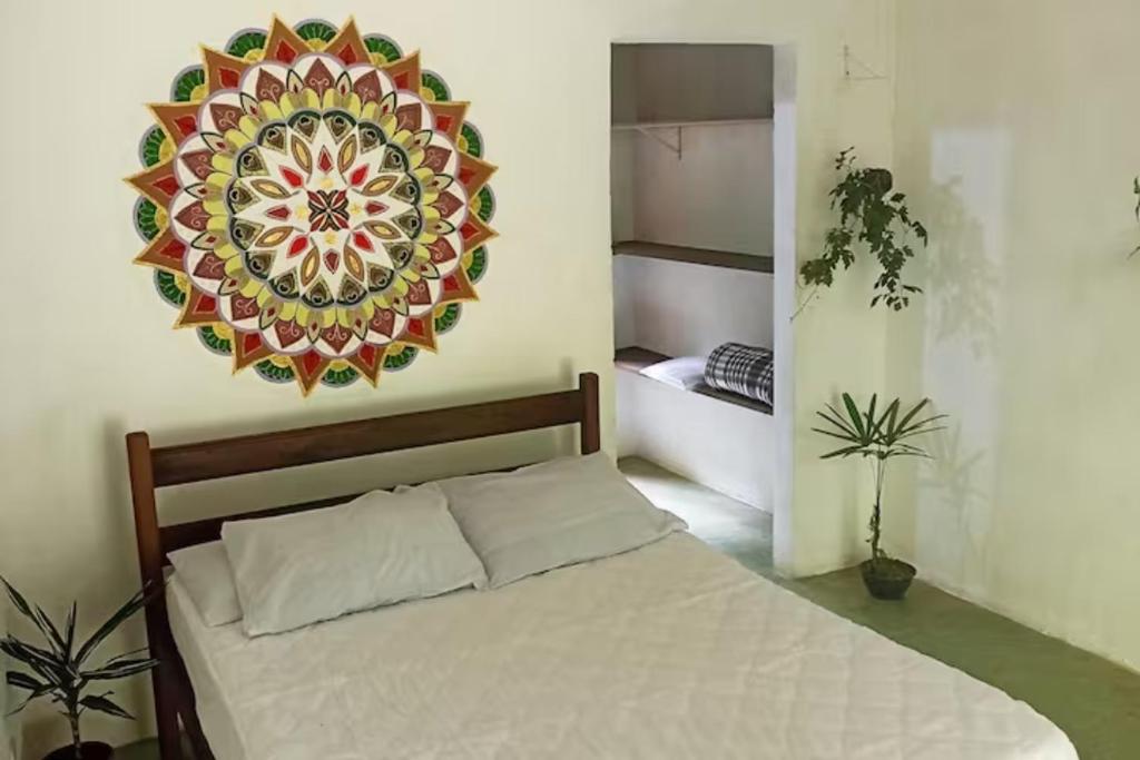 a bedroom with a bed with a mandala on the wall at Pousada Portal Floresta Paraty in Paraty