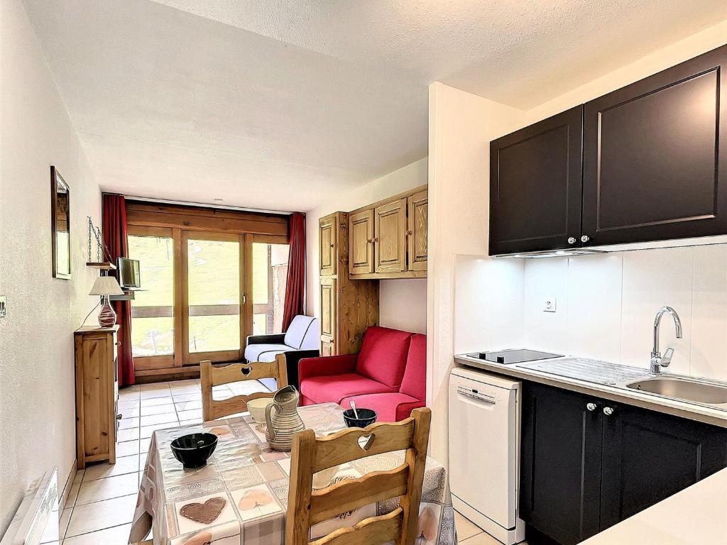 - une cuisine avec une table et un canapé rouge dans une chambre dans l'établissement Studio lumineux avec balcon - Pied des pistes, piscine, parking et commerces à proximité - FR-1-267-218, au Corbier