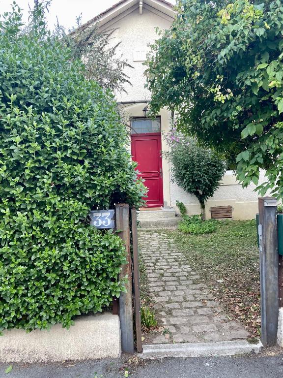 une maison avec une porte rouge et quelques buissons dans l'établissement Les chambres de Nita - Guest House, à Bergerac