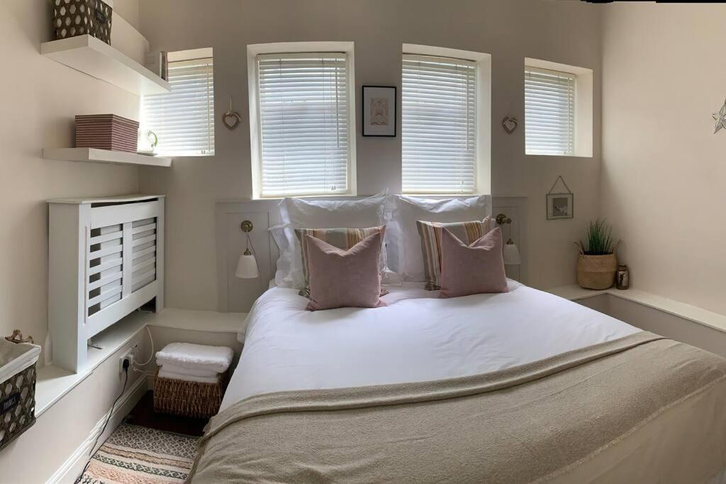 a bedroom with a large bed with white sheets and pillows at Abbey and Clock Tower view in Saint Albans