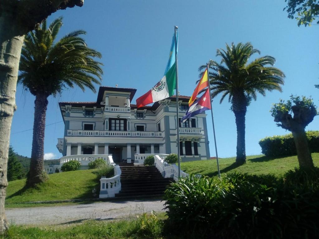 una casa con banderas en una colina con palmeras en Villa Alicia LA PERLA INDIANA, en Salas