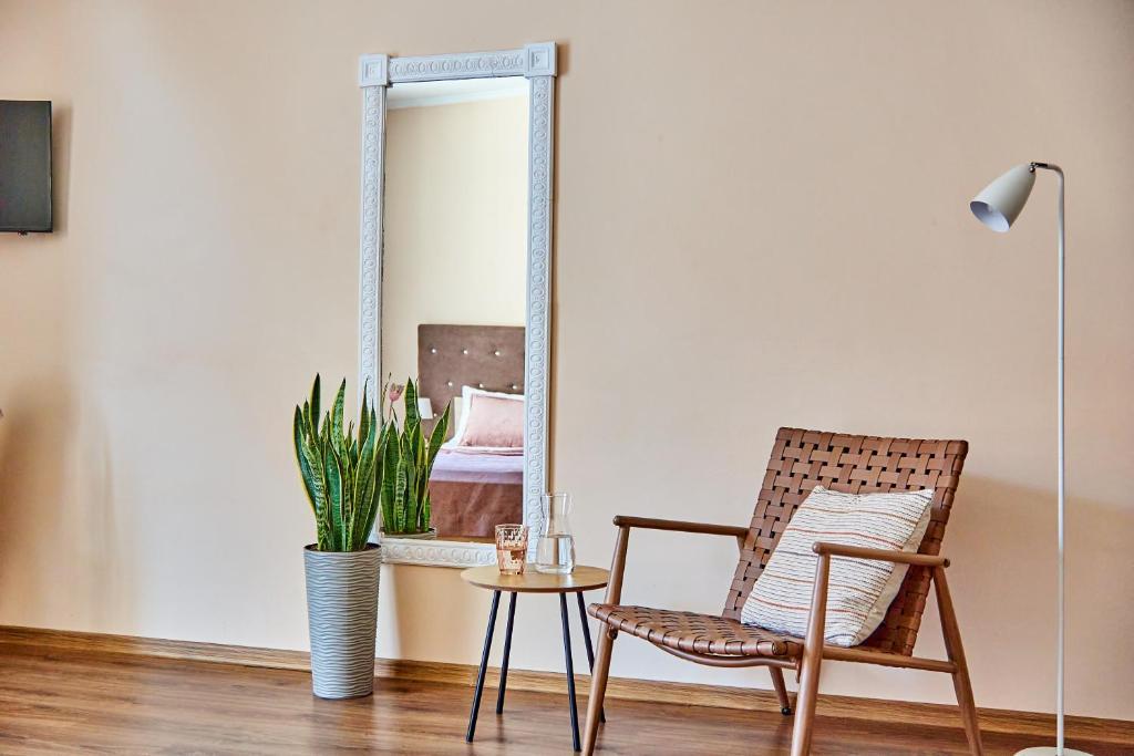 Una sala de estar con una silla y un espejo. en Елегантні Люкс Апартаменти в центрі Мукачева, en Mukácheve