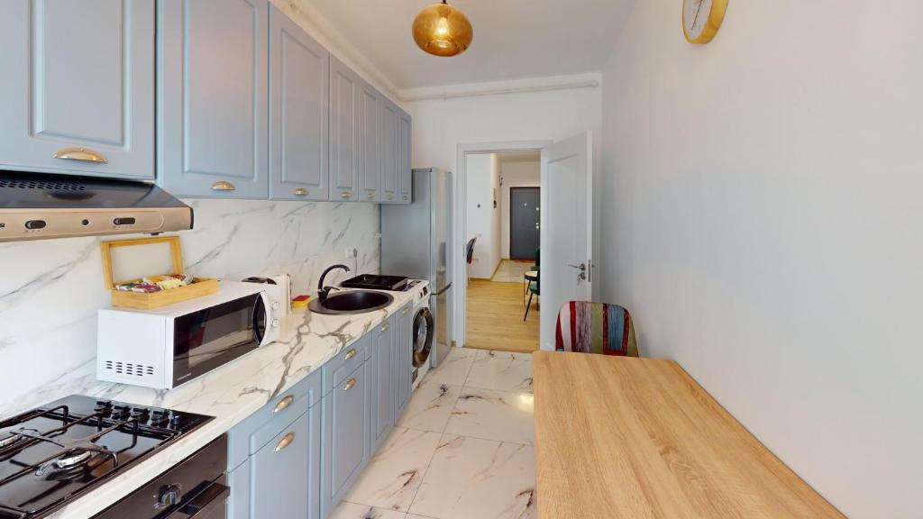 a kitchen with white cabinets and a counter top at Serenity Retreats VRT in Sibiu