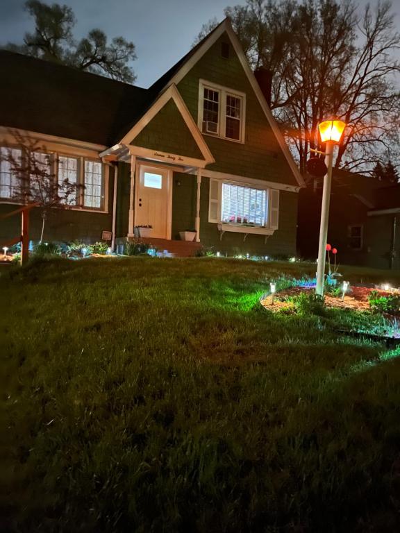 une maison éclairée dans la cour la nuit dans l'établissement Cozy Cape Cod, à Grand Rapids