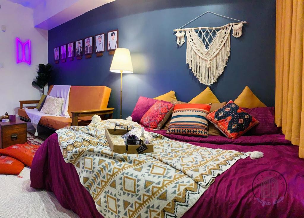 1 dormitorio con 1 cama grande y almohadas coloridas en The Room: Magic Shop en Tagaytay