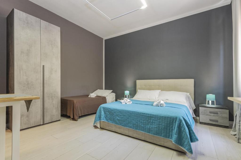 1 dormitorio con 1 cama con manta azul en Moca Rooms, en Bari