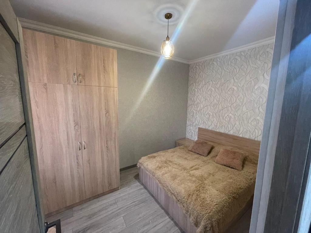 1 dormitorio con 1 cama y armario de madera en ByurHouse, en Byurakan