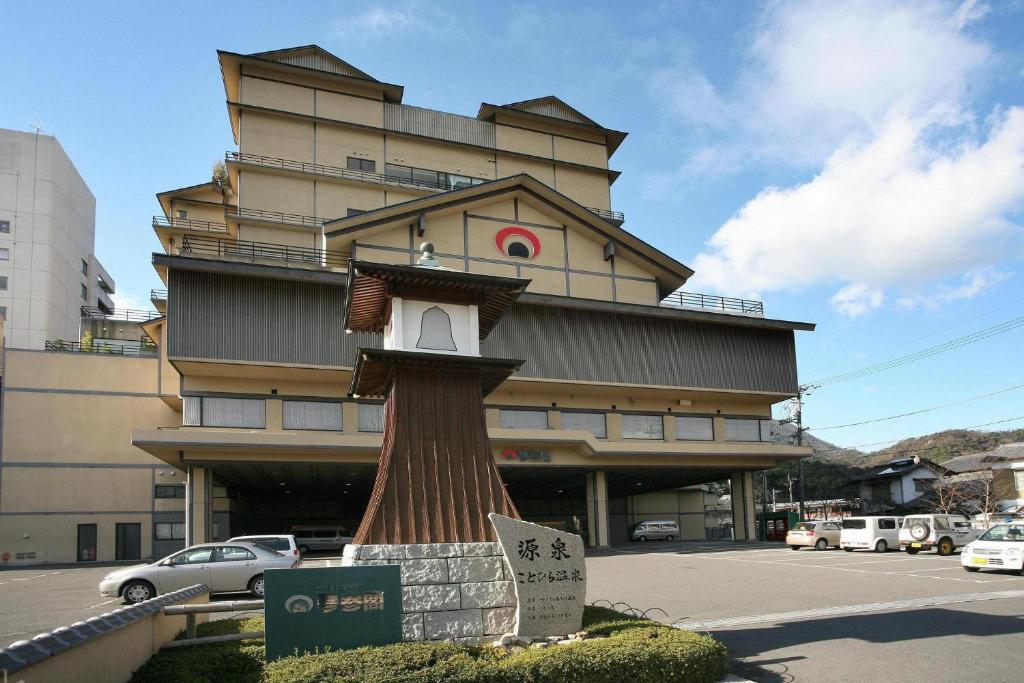 un bâtiment avec une tour d'horloge devant lui dans l'établissement Kotohira Onsen Kotosankaku, à Kotohira