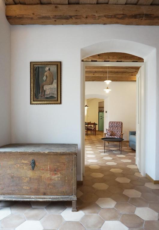 a living room with a wooden ceiling and a table at Old Town Flat with Private Patio in Kutná Hora