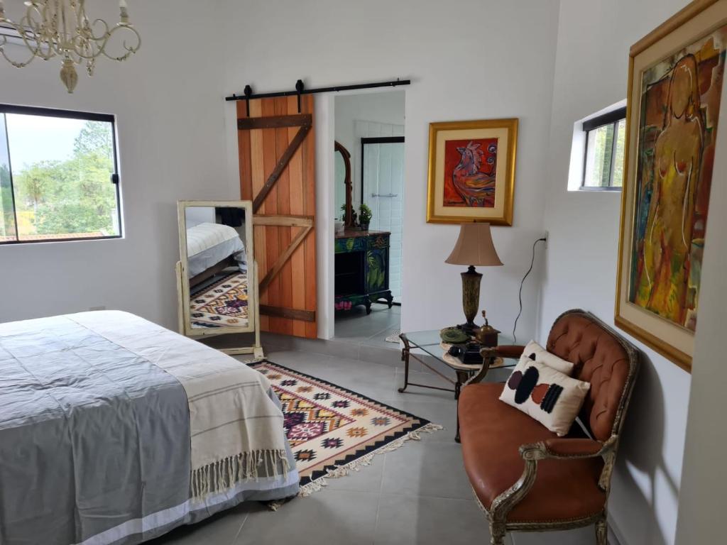 a bedroom with a bed and a chair and a mirror at La Pinta Hotel Boutique in San Bernardino