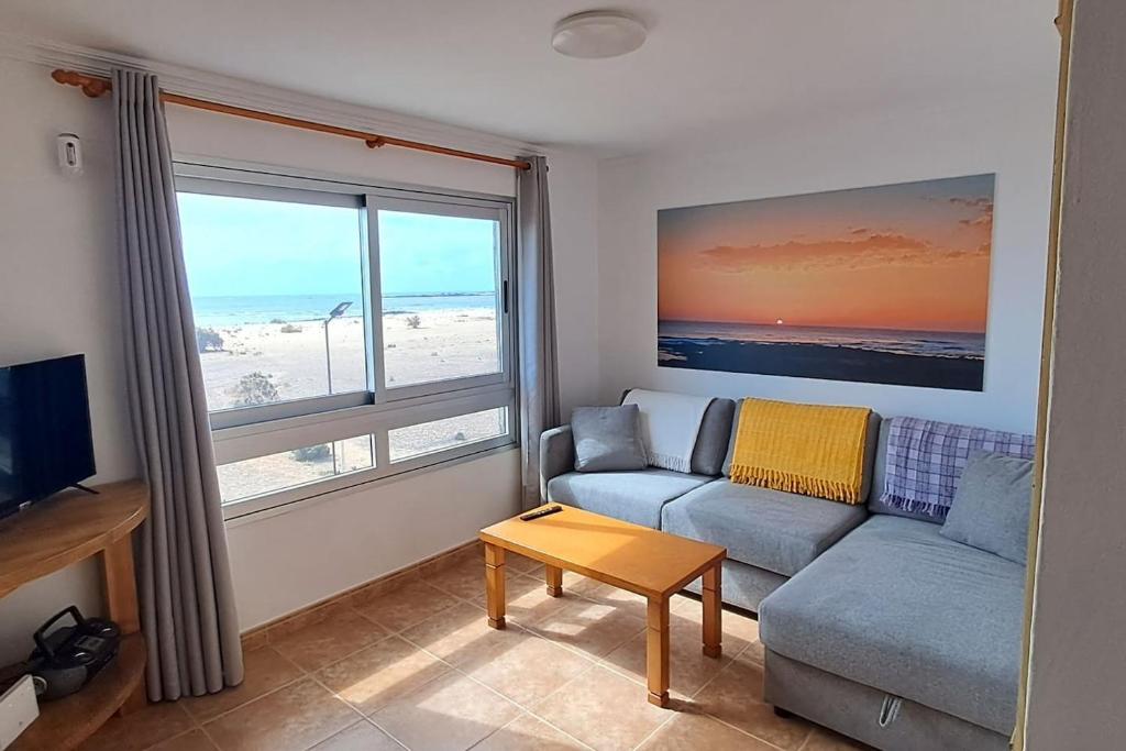 a living room with a couch and a large window at Casa Abuelo Antonio in El Cotillo