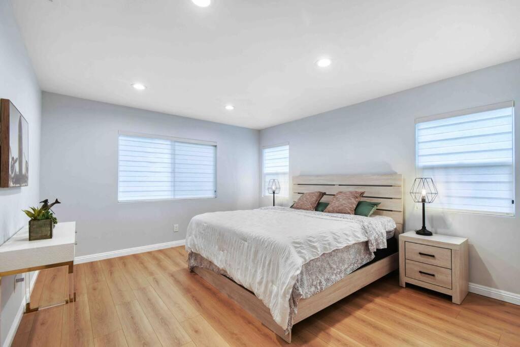 a bedroom with a large bed and two windows at Spacious & Modern 4B3B house in Pasadena in Pasadena