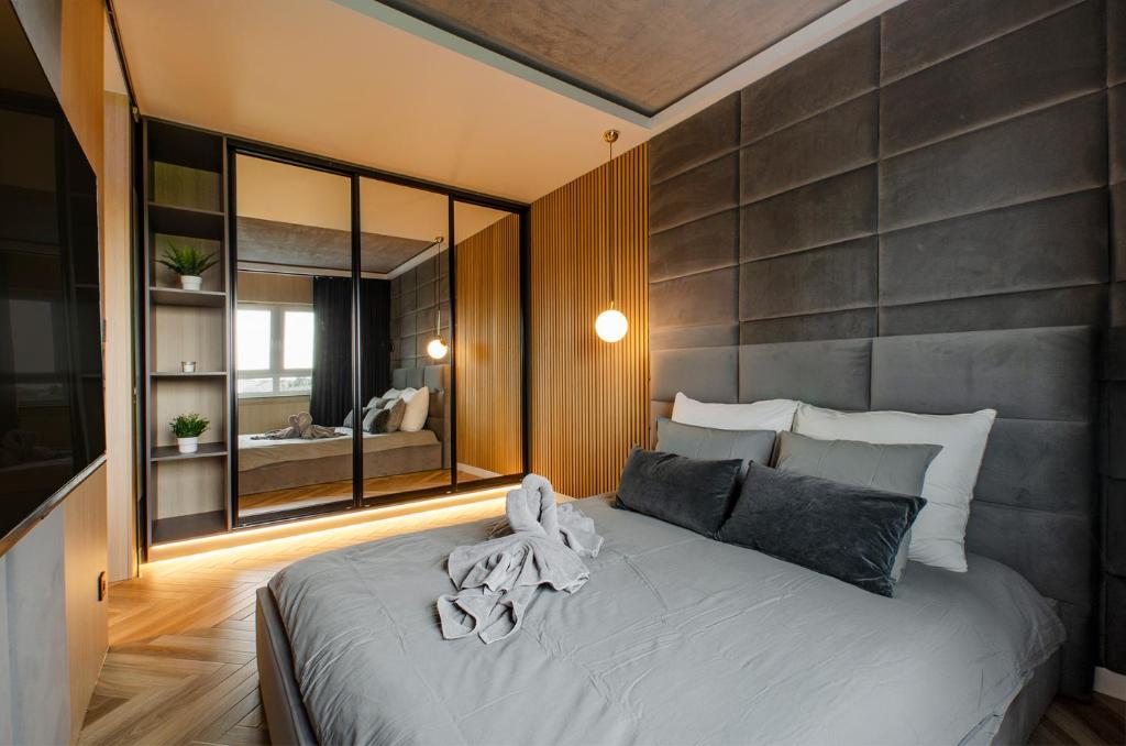 um quarto com uma cama grande e um espelho grande em SKY Home- Wood Penthouse -Manufaktura, Parking, Klimatyzacja, Dostęp na Kod em Lódź