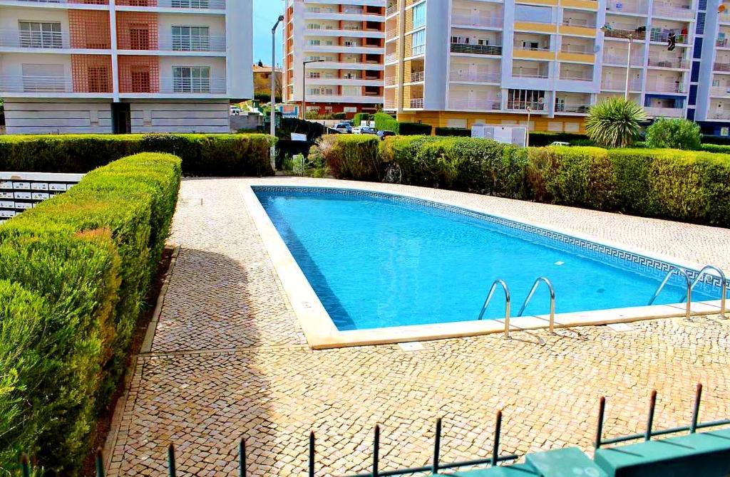 une grande piscine bleue dans une ville dans l'établissement ApartamentoSolPraia - FAIA, à Portimão