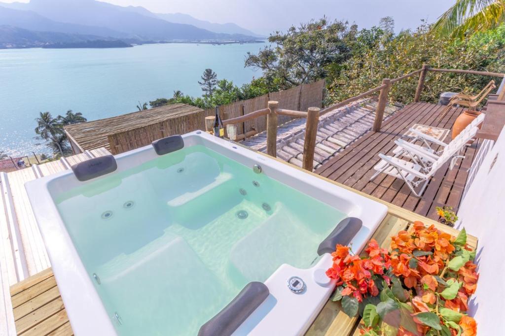 bañera de hidromasaje en una terraza con vistas al agua en Cobertura com Incrível Vista de Cinema para o Mar, en Ilhabela