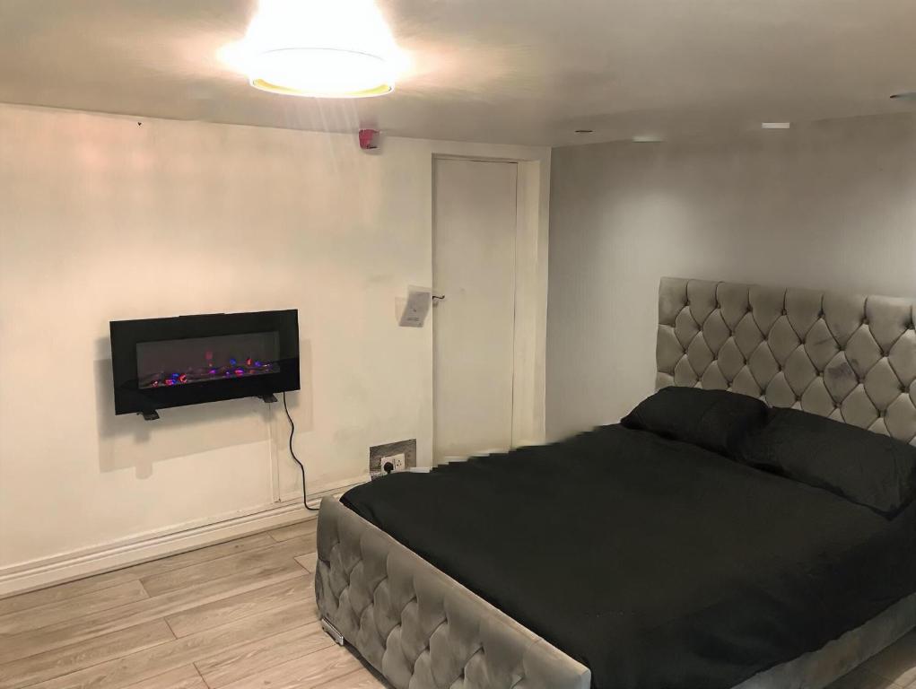 a bedroom with a bed and a flat screen tv at 1 Bedroom Apartment by London Stratford in London