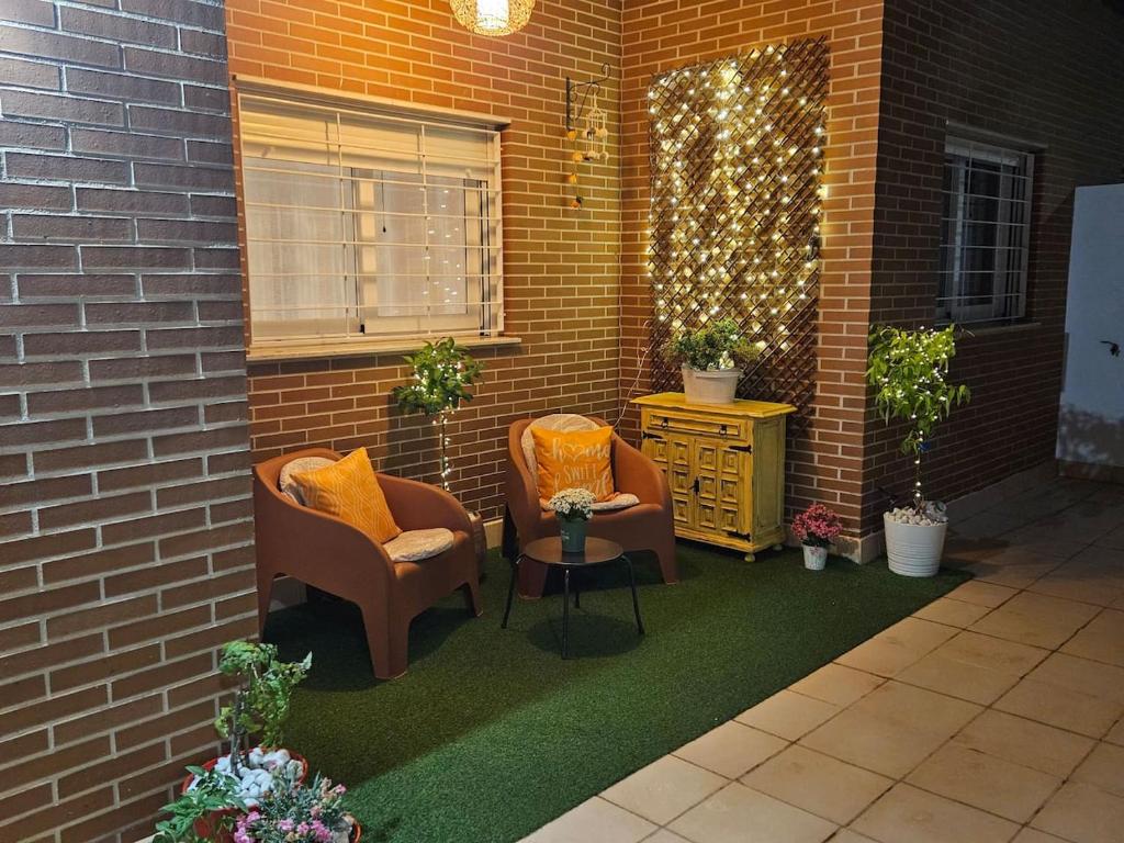 a patio with two chairs and a table and a brick wall at Ksota in Requena