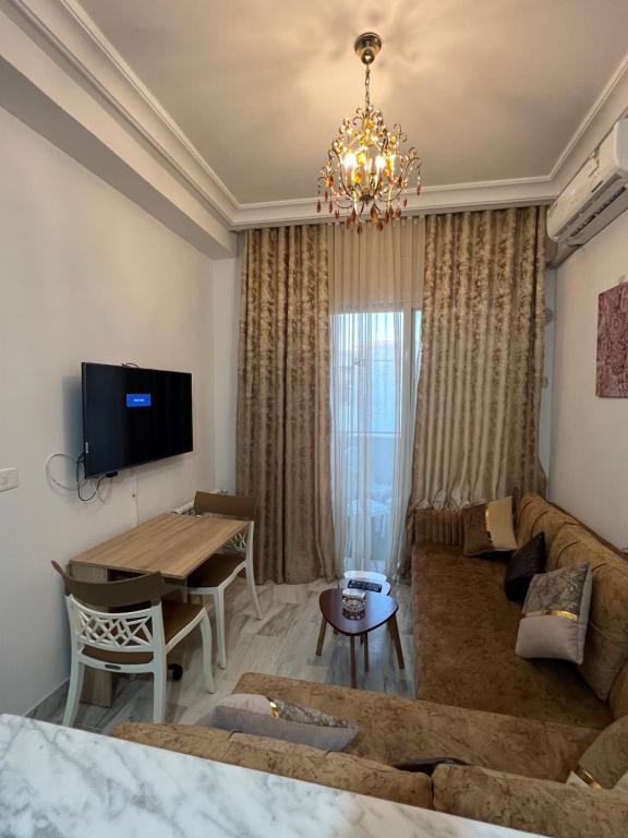 sala de estar con sofá y mesa en Appartement L'aouina cité wahat en Túnez