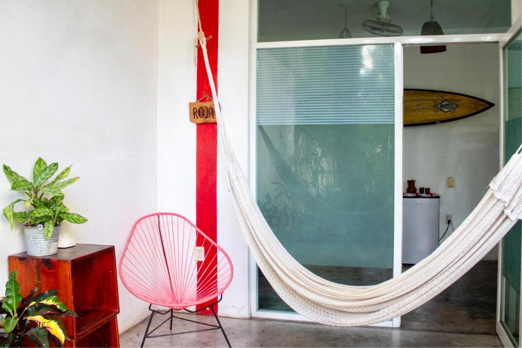 una camera con amaca, sedia e finestra di Casa Daikiri a Puerto Escondido