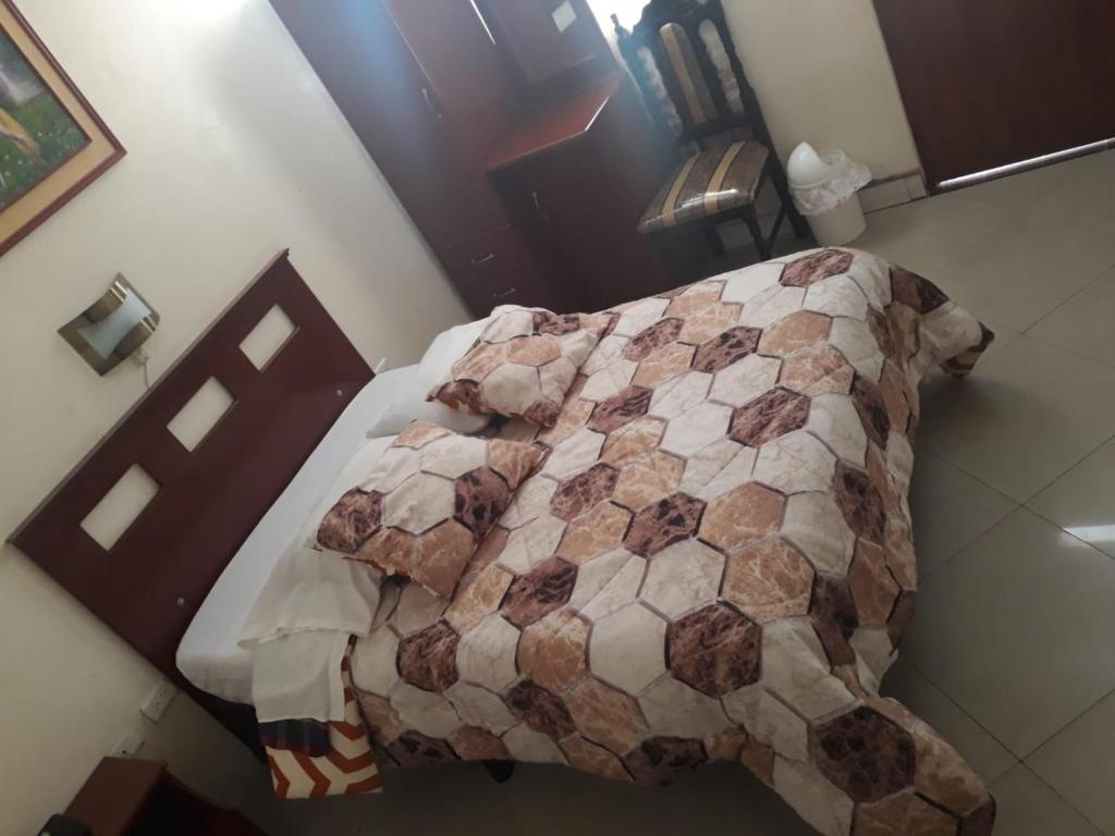 un letto con una trapunta in una stanza di Hotel Richard's a Riobamba
