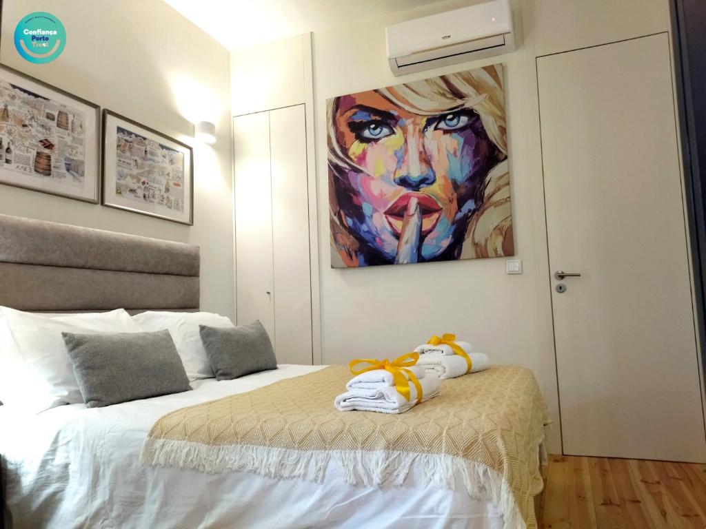um quarto com uma cama com um quadro na parede em Santa Catarina Patio Apartment - com possibilidade Parking no Porto