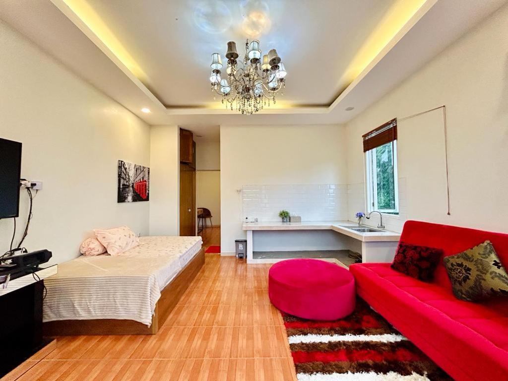 ein Schlafzimmer mit einem Bett und einem roten Sofa in der Unterkunft Arum Bromo Villas in Ngadisari