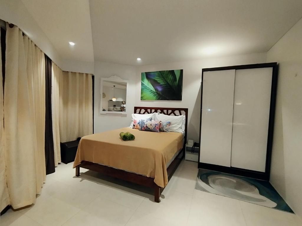 1 dormitorio con 1 cama y una pintura en la pared en Family Room en Maribago