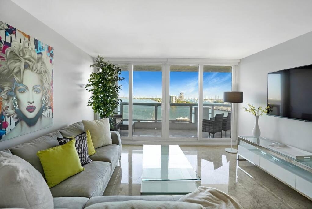 a living room with a couch and a glass table at Only in My Dreams! Direct Water View Luxury Condo in Miami